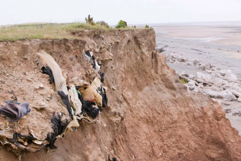 O desperdício tóxico está derramando nas praias, enquanto os mares crescentes corroem os aterros sanitários